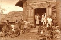 Minlaba, le dispensaire. - L’effort sanitaire colonial au Cameroun porte avant tout sur la lutte contre la maladie du sommeil. L’affection, endémique dans la région, a en effet pris un tour épidémique catastrophique à la fin du XIX ème siècle, avec la circulation des populations engendrée par la pénétration coloniale et par les mouvements de main d’œuvre, vers les plantations notamment. En quelques décennies, la trypanosomiase emporte plusieurs millions de personnes, dans une hécatombe restée sans équivalent. Du temps de leur occupation, les Allemands prennent la mesure du problème et ébauchent un dispositif, essentiellement basé sur la concentration des malades dans des sites dédiés ou, pour le moins, en préparant des lieux d’accueil. Les Français reprennent l’idée à leur compte, mais en la sophistiquant selon les principes établis par Eugène Jamot, le maitre de la lutte contre la maladie du sommeil. Ils consistent à débusquer manu militari les patients dans les villages grâce à des équipes mobiles, à traiter les moins atteints dans les dispensaires et les postes de santé avancés –auxquels sont également dévolus les soins courants pour les autres affections- et à transporter les plus malades dans des « hypnoseries », établissements spécialisés dans leur traitement. Voici la description d’un de ces postes avancés, faite au milieu des années trente : « Les hôpitaux sont supplées, pour les cas bénins, par des infirmeries de brousse. Une case à trois compartiments, dont l’un sert de chambre à l’infirmier. Des thermomètres, des compresses, des bandes, des seringues, une armoire à médicaments, d’où l’on a exclu les poisons qu’on ne confierai pas sans péril à un indigène même diplômé. C’est tout. C’est déjà beaucoup ». Source : J. Wilbois Le Cameroun, éditions Payot, Paris, 1934.