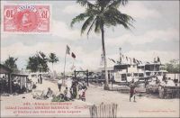Grand Bassam, Marché et Station des bateaux de la Lagune. – Situé à l’interface entre l’océan et la lagune Ebrié, un des cordons côtiers qui longent une bonne partie du littoral, le site s’impose naturellement comme capitale dès la création de la colonie de Côte d’Ivoire en 1893. Il permet en effet d’organiser à la fois les échanges maritimes vers l’extérieur du continent et les communications vers l’intérieur du pays. Un réseau lagunaire et fluvial relie les principales agglomérations du sud du pays et les cours d’eau servant à l’époque de voie de communication vers le nord, faute de pistes. Au départ, les transbordements depuis ou vers les navires en mer sont assez périlleux. La côte d’Afrique de l’Ouest est en effet exposée à un système de vagues et de courants très violents, appelé « la barre ». Des piroguiers audacieux se sont spécialisés dans son franchissement, mais l’opération reste risquée pour les marchandises comme pour les passagers. A la toute fin du XIXe siècle, Grand-Bassam est dotée d’un wharf, sorte de ponton érigé de la plage vers l’océan, permettant de charger et décharger les navires de l’autre au-delà de la barre. Malgré ses atouts et ses équipements, le développement de la ville est stoppé par une épidémie de fièvre jaune meurtrière en 1899 – 45 des 60 Européens résidents y laissent la vie – et la capitale est transférée dans une localité située de l’autre côté de la lagune, baptisée Bingerville - en hommage au premier gouverneur de la colonie de Côte d’Ivoire, Louis-Gustave Binger. Ce cliché fait partie de l’important fond constitué par le photographe dakarois Edmond Fortier. Il se rendit en Côte d’Ivoire en 1908, accompagnant le voyage officiel du ministre des colonies du premier gouvernement Clémenceau, Raphaël Milliès-Lacroix.