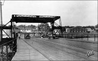 Abidjan, entrée du pont de Treichville. - Cet ouvrage un peu primitif - un pont flottant -, édifié en 1931, occupait approximativement l’emplacement de l’actuel pont Houphouët Boigny. Franchissant la lagune Ebrié, il reliait le quartier du Plateau, au nord, au quartier de Treichville au sud. Il fut détruit en 1957, pour céder la place au nouveau pont. Celui-ci, construit en béton précontraint sur des pieux profonds, comporte 8 travées pour une portée totale de 372 mètres. A la fin des années 1960, un autre pont, nommé pont Charles De Gaule fut édifié selon les mêmes techniques, à quelques centaines de mètres à l’est du pont Houphouët-Boigny, pour absorber une partie du trafic automobile en plein essor. Ce nouvel édifice, long de 592 mètres, est d’ailleurs dévolu à l’usage routier. Aujourd’hui, on annonce la construction prochaine d’un troisième pont sur la lagune Ebrié. Le nouvel ouvrage, qui portera le nom de l’actuel président de la république ivoirienne – au pouvoir depuis 2000 et maintenu dans ses fonctions par des accords internationaux en attendant que la situation militaire et politique permette l’organisation de nouvelles élections présidentielles –, reliera le quartier de Yopougon à l’île Boulay. Jusqu’à présent isolée, celle-ci constitue une vaste étendue proche du centre ville, disponible pour l’extension. Elle devrait accueillir de nouvelles infrastructures portuaires, une zone franche industrielle et commerciale, et un quartier d’affaires. Trois consortiums, un français, un italien et un allemand, sont en lice pour obtenir le chantier de ce pont.