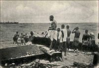 Embarquement de billes d’acajou. - « On parlait aujourd’hui des bois de la Côte d’Ivoire et l’on déplorait que les ébénistes français se servissent si peu des produits de nos colonies. Je citai Sue et Mare me disant que, quand ils avaient acheté en France une certaine qualité de bois exotiques, ils n’étaient jamais sûrs de retrouver ensuite la même, tant nos marchands en gros achètent à tort et à travers, au hasard des marchés. […] La baisse du franc du franc a mis nos acajous à des pris si peu élevés que plusieurs maisons américaines se sont installées à Grand-Bassam. Elles envoient nos bois précieux aux Etats-Unis d’où ils nous reviennent en France sous le nom d’acajou d’Amérique ». Source : Morand, Paul, A.O.F. de Paris à Tombouctou, Paris, Flammarion, 1928.