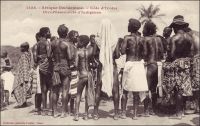 Côte d’Ivoire, divertissement d’indigènes. – « J’assiste à une curieuse représentation. Ce sont des hommes qu’on a fait venir d’un village voisin, qui jonglent et font mille tours avec des petites filles de cinq à six ans. Ces petites sont nues, avec une ceinture de perles de couleur et au front un diadème de pot de panthère et de coquillages. Au son des tambours, avec une violence rythmée, les hommes les empoignent, détendues, les dressent, raidies, les laissent tomber, se les passent autour du cou, font avec ces petits corps d’étranges moulinets, vous les jettent à la figure et les rattrapent par un pied,  au dernier moment. Ces actrices enfants se laissent faire avec indifférence ; leurs jeunes os sont flexibles comme du caoutchouc, et il n’y a aucune limite à leur souplesse » (1). Cette image fait partie du travail du célèbre photographe et éditeur dakarois Edmond Fortier (1862-1928) à qui l’on doit une somme importante de clichés sur toute l’Afrique de l’Ouest. M. Fortier tenait boutique non loin du marché Kermel, à l’angle de la rue Dagorne et du boulevard Pinet-Laprade. Source : (1) Morand, Paul, A.O.F. de Paris à Tombouctou, Paris, Flammarion, 1928.