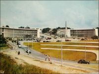 Abidjan, la Place Lapalud. – Construite en 1957, elle est inaugurée le 15 mars 1958 en même temps que le pont Houphouët Boigny qu’elle prolonge.  En forme d’hémicycle, elle constitue la pointe sud de la presqu’île lagunaire du Plateau. Elle porte en son centre un monument emblématique, constitué d'une colonne verticale en dessous de laquelle se trouve la statue d'une femme portant sur sa tête un panier rempli de feuilles. La légende veut qu’une femme rencontrée un jour en ce lieu soit à l’origine du nom de l’actuelle capitale économique de la Côte d’Ivoire. Ainsi, au XVIIIème  siècle, des français, venus reconnaître l’endroit, croisèrent là une femme rentrant de la cueillette. Tandis qu’ils lui demandaient d’où elle venait, elle répondit « t'chan m'bi djan », ce qui signifie « j'étais allé couper des feuilles » en Ebrié. Transcrit phonétiquement, ce que les explorateurs avaient pris pour le nom du lieu, devait rester. La place, qui portait le nom de Maurice-Pierre Lapalud, gouverneur de la Côte d’Ivoire entre 1925 et 1930, fut rebaptisée en 1961 place de la République. Le boulevard Antonétti, du nom du gouverneur colonial de 1918 à 1924, et que l’on voit sur cette photo monter vers l’intérieur du Plateau entre les bâtiments de la Poste et de la direction des douanes, devait quant à lui devenir boulevard de la République.