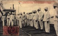 Voyage du Ministre des colonies à la Côte d'Afrique. Côte d’Ivoire, débarquement à Port-Bouët.  – Il s’agit du déplacement de Raphaël Milliès-Lacroix, ministre des colonies dans le premier gouvernement Clemenceau, qui s’embarqua le 13 avril 1908 à Lisbonne sur un navire des Messageries Maritimes et visita successivement le Sénégal, la Guinée française, la Côte d’Ivoire et le Dahomey. Ce voyage, sous le signe de l’étude plus que du protocole (outre le ministre, la délégation ne comptait que deux collaborateurs), rencontra un chaleureux accueil des colons. Il fut couvert par le photographe Edmond Fortier de Dakar qui rejoignit la mission dès cette première escale. Il semble que la localisation précise de cette photo soit inexacte. La légende situe cette scène datant de 1908, et qui se déroule sur un wharf portant en arrière plan une grue à vapeur, sur le wharf de Port-Bouët qui n’a été construit qu’en 1931. Il s’agit vraisemblablement du wharf de Grand Bassam, construit en 1897 et par lequel dut forcément débarquer le ministre.