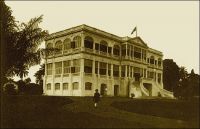 Le Palais du Gouverneur à Bingerville. – Il a fallut sept ans, entre 1905 et 1912, pour construire ce bâtiment qui reste considéré comme un joyau de l’architecture coloniale en Côte d’Ivoire. Il doit son existence au déménagement de la capitale, qui quitte fin 1900  la ville littorale de Grand-Bassm dévastée par plusieurs épidémies successives de fièvre jaune et qu’on a fini par incendier partiellement pour raison sanitaire. L’administration coloniale s’installe alors dans un lieu plus aéré et considéré comme salubre, situé sur les collines qui surplombent la lagune Ebrié, le village d’Adjamé-Santey. Rebaptisée Bingerville, la localité doit son nom au premier gouverneur de la colonie, Louis Gustave Binger. Elle reste la capitale de Côte d’Ivoire jusqu’en 1934 où elle cède ce rôle à la ville d’Abidjan, qui le cèdera à son tour à celle de Yamoussoukro en 1983. Le palais du gouverneur de Bingerville est maintenant un orphelinat de garçons.