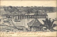 Beach and landing place at Sekondi, 1903, (la plage et la zone d’accostage de Sekondi en 1903). – La ville côtière de Sekondi, dans l’Ouest de la Gold Coast, connait un important essor au tout début du XXème siècle. Elle bénéficie, après la guerre de 1900-1901 qui a permis de soumettre le pays ashanti, de gros investissements en infrastructures destinés à évacuer les richesses provenant des nouveaux territoires septentrionaux. Ainsi, une ligne de chemin de fer reliant Kumasi est déployée à partir de 1903 et un nouveau port est ouvert au trafic durant la décennie suivante. Ce dispositif permet d’acheminer le cacao, dont l’agriculture se développe, les bois tropicaux et les produits miniers et en particulier l’or dont l’extraction a bondit grâce aux investissements européens. La ville s’est développée autour du site d’un ancien fort hollandais du XVIIème siècle (une soixantaine de forts sont bâtis le long des 500 km de côtes de l’actuel Ghana à partir du XVème siècle par plusieurs puissances européennes). La ville voisine de Takoradi, sur le site d’un ancien fort anglais à quelques kilomètres à l’ouest de Sekondi, se développe à son tour dans les années suivant la première guerre mondiale. Elle est en effet choisie, par le gouverneur Gordon Guggisberg, pour recevoir le port en eau profonde qui portera le développement économique de la colonie. Les deux villes sont officiellement réunies en 1946, sous le nom de Sekondi-Takoradi.