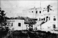 Cape Coast, Government House , en 1873. – La maison du gouverneur semble dater du début du XIXème siècle, elle est en effet quelques fois désignée comme « maison Hope-Smith » du nom d’un gouverneur de l’établissement de Cape Coast en poste vers 1915. L’édifice abrite aujourd’hui un certain nombre de services publics, et son élégante architecture d’origine est masquée par l’adjonction de multiples vérandas. La ville de Cape Coast demeure la capitale de la Gold Coast jusqu’en 1877, mais Accra, qui s’impose alors, était devenue le principal pôle commercial dès le milieu du siècle.