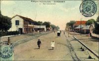 Conakry, rue commerciale. - Connue également comme avenue commerciale, rue, avenue ou boulevard du Commerce ou encore « 3ème boulevard », cette artère majeure de la capitale guinéenne aboutit au port. L’administrateur Bie la décrit ainsi en 1899 : « n’a pas moins de 30 m. de large sur une longueur d’environ un kilomètre. De larges trottoirs bordant cette rue, de splendides maison à étage, toutes neuves, lui donnent une apparence toute moderne » (1). Le chemin de fer Decauville, que l’on distingue sur l’image, fut déployé dans ce quartier de négoce à partir de 1897. Cette installation, constituée de rails écartés de 60 cm et fixés sur des traverses métalliques, était souvent désignée comme « petite vitesse », par opposition au chemin de fer plus rapide et en voies métriques qui joignait le fleuve Niger. A partir de 1902, elle totalisait 9,7 kilomètres de voies. Son usage n’était pas réservé au commerce, et les particuliers pouvaient y faire circuler des marchandises, moyennant un droit de 1 franc par tonne transportée et en fournissant le véhicule et son mode de traction. Les wagonnets de promenade, emportant des passagers, n’étaient pas soumis à cette taxe. Source (1) : Bie. A. (administrateur), Voyage à la côte occidentale d’Afrique, de Marseille à Conakry, Conakry le 20 mai 1899 (archive privée citée par Odile Goerg dans Rives Coloniales, Soulilou, Jacques, éditeur scientifique, Paris, édition Parenthèses et édition Orstom, 1993).