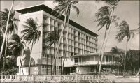 Conakry, l’Hôtel de France. – « Pour atteindre le port, les navires doivent contourner les îles Los et défiler venant du sud entre la cité rouge et verte des « Bauxites du Midi » fixée dans les îles, et le quartier résidentiel de Conakry, bouquet vert d’où jaillissent de puissants buildings de dix à quinze étages, l’hôtel de France et aussi la coupole de la cathédrale avec ses deux tours. […] on y goutte, aussi un peu, le confort de l’hôtel de France, achevé en 1954 et qui représente au bord de la mer, face aux îles, avec l’immense rotonde ventilée de sa salle à manger, un de ces haut lieux de rencontre où la camaraderie facile des Blancs d’Afrique s’exprime avec aisance et légèreté. » Source : La Guinée Française, Cahiers Charles de Foucauld, Paris, 1957.