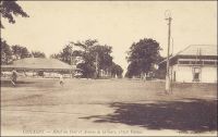 Conakry, Hôtel du Port et avenue de la Gare, petite vitesse. – La « petite vitesse » désigne le chemin de fer Decauville, dont on voit ici les rails au milieu des rues, qui sillonnait la ville de Conakry, comme celles de beaucoup d’autres capitales coloniales africaines. Les voies Decauville étaient constituées de rails écartés de 60 cm, fixés sur des traverses métalliques. – « Philippe, s’exclama tout à coup Andrée, je ne comprends rien à votre Decauville. Tout à l’heure, j’y voyais passer un train minuscule, puis ce fut un camion chargé de pierres et traîné, à bras, par des Noirs. Maintenant, regardez cette voiture élégante où trône une jeune femme, à demi cachée sous son ombrelle, tandis que son compagnon conduit le cheval. – Notre Decauville, expliqua Dorhez en souriant, n’est pas, comme en France, un égoïste, gardant les rails pour lui tout seul. Ici, ce chemin de fer sur route est mis à la disposition du commerce et même des particuliers, moyennant un droit fixé à un franc par tonne. Chacun fournit son véhicule et son moyen de traction. – Comme à Rufisque, remarqua l’Oncle Guy. – Un franc la tonne, reprit Andrée, alors cette jeune dame... -- ... n’a pas besoin de se peser, rassurez-vous, répliqua Dorthez. Ici les wagonnets de promenade ne payent aucune taxe ». Source : Decourt, Dr Ferdinand, La famille Kerdalec au Soudan, Paris, Ed. Librairie Vuibert, 1910.