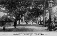 Kankan, rue du commerce. - « Arrivée à la gare de Kankan peu avant midi. Les chefs indigènes, dont un descendant de Samory, viennent nous voir à la gare, drapés, la tête enveloppée de linges blancs, assez semblables à des Flamands du XVème siècle. Dehors, la milice composée d’anciens tirailleurs, khaki et rouge, porte les armes. Alors éclate, comme une bombe sous le soleil, dans la poussière, avec une brusquerie extraordinaire, mon premier tam-tam d’Afrique »(1). « Jusqu’en 1911 l’orientation soudanienne demeura prépondérante : les marchandises d’importation arrivaient de Bamako à Kouroussa (terminus des 400 km du bief navigable supérieur du Niger) et à Kankan (par le Milo). La construction du chemin de fer et celle du réseau routier ont renversé l’orientation traditionnelles des courants d’échange au bénéfice de Conakry et donné à Kankan un nouvel essor » (2). Sources : (1) Morand, Paul, A.O.F. de Paris à Tombouctou, Paris, Flammarion, 1928 ; (2) Suret-Canale, Jean, La République de Guinée, Paris, Editions Sociales, 1970. - Cette carte fait partie du travail du célèbre photographe et éditeur dakarois Edmond Fortier (1862-1928) à qui l’on doit une somme importante de clichés sur toute l’Afrique de l’Ouest. M. Fortier tenait boutique non loin du marché Kermel, à l’angle de la rue Dagorne et du boulevard Pinet-Laprade. Cette photo doit dater de 1905. Edmond Fortier avait effectué un voyage en Guinée en 1902 ou 1903, mais il semble qu’il soit allé à Kankan par le fleuve, comme cela se faisait avant l’arrivée du chemin de fer, depuis Bamako, à l’occasion d’un périple au Soudan français en 1905.