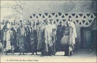 Le Morko-Naba du Mossi. – « Hier, à Ouagadougou, j’ai été rendre visite au Moro-Naba, le roi de tout le pays Mossi. Il règne sur deux à trois millions de sujets et ses ancêtres furent en rapport avec les Portugais. M. Delafosse a même pu établir la chronologie des rois Mossi jusqu’à l’an mil. Le roi m’attend sur la porte de son palais, entouré de sa cour. Il est obèse ; une vraie outre noire, grasse ; l’air sensuel, féroce et malin. Barbiche, joues énormes. C’est bien le dernier roi nègre, celui de mes livres d’enfant. Il porte une énorme couronne d’or, une robe de velours violet soutachée d’or, et rafraîchit ses lourdes lèvres violacées d’une petite langue de carmin qui égaye de sa couleur tout le visage. Il me présente ses ministres, ses scribes, ses eunuques, ses pages, très beaux et vêtus de robes, coiffés en cimier, comme des femmes, comme elles guêtrés de jambières de cuivre de vingt centimètres de haut, parés de lourds anneaux de cuivre rose, d’une tonalité merveilleuse sur la peau nue. […] J’offre au Moro-Naba un bracelet d’émeraudes, acheté à Paris dans une de ces boutiques de faux à « tout pour cent francs… » (1). - Il doit s’agir du Mogho Naaba Koom II (1889 – 1942), l'arrière grand-père du Mogho Naaba actuel, qui régna du 27 février 1905 à sa mort, le 12 mars 1942. Il avait choisi pour devise « Que l'eau abonde pour tous ». Il repose, ainsi que sa femme, au centre de la place qui porte son nom devant la gare ferroviaire de Ouagadougou, sous la masse d'une statue métallique de 6 mètres de haut représentant une femme mossi stylisée offrant l'eau de bienvenue à un hôte invisible. Mogho Naaba Koom II s’était rallié à la France Libre dès le 22 juin 1940, alors que Paul Morand, dont on sent percer le dédain dans les lignes que lui a consacrées, sera nommé ambassadeur de France en Roumanie puis en Suisse par Vichy. Source : (1) Morand, Paul, A.O.F. de Paris à Tombouctou, Paris, Flammarion, 1928.
