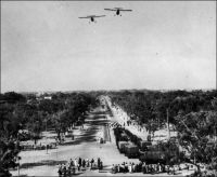 Ouagadougou fête l’indépendance de la Haute-Volta, au début des années 1960 (photo publiée courant 1963). – La colonie de Haute-Volta, créée en 1919, puis supprimée et intégrée aux colonies françaises mitoyennes entre 1932 et 1947, devient une république au sein de la Communauté française le 11 décembre 1958. La Haute-Volta accède à l’indépendance le 5 août 1960. Pourtant, le Burkina Faso a récemment pris le parti de célébrer son indépendance le 11 décembre. Ce transfert de date anniversaire n’est pas fortuit. D’une part la date du 5 août était trop proche dans le calendrier de celle du 4 août, anniversaire de la prise du pouvoir par le populaire capitaine Thomas Sankara en 1983, lequel sera liquidé quatre ans plus tard par des hommes à la solde de l’actuel président Compaoré. D’autre part, pour la majorité de la population, qui n’a pas connu l’époque coloniale, la première quinzaine de décembre correspond à la commémoration de l’assassinat du journaliste Norbert Zongo, le 13 décembre 1998. L’homme de presse, qui s’acharnait à traquer les crimes et turpitudes du pouvoir, accusait notamment le frère du président Compaoré d’avoir fait assassiner son chauffeur pour une obscure histoire de vol. Le journaliste a été exécuté, avec ses compagnons de voyage, près de la localité de Sapouy, sur une piste bordée de caïcédrats qui va de Léo à Ouagadougou. L’événement avait soulevé une violente émotion populaire, qui se ranime chaque année au moment de l’anniversaire de la tragédie. Des enquêtes indépendantes ont établi la responsabilité de membres de la garde présidentielle dans cet attentat, sans pourtant qu’aucun n’ait été condamné par la justice burkinabè. Le changement de date de la fête d’indépendance permet de libérer salariés, élèves et étudiants pour une semaine fériée, amenuisant le risque d’une émulation qui générait jusqu’alors des émeutes chaque année. - Les appareils qui évoluent en formation semblent être les deux Broussards (Max Holste MH 1521), dont l'ancien colonisateur a doté l'armée de l'air voltaïque naissante. L'armée voltaïque a vu le jour le 1er novembre 1961.  Les autres anciennes colonies françaises d'Afrique noire ont aussi reçu leur lot de Broussards : 5 pour le Sénégal, 6 pour le Tchad, 4 pour le Togo...