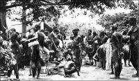 Marché à Gaoua, en pays lobi, dans les années 1930. – « Gaoua, comme tous les centres, a beacoup perdu de son caractère. Une population très mélangée, comprenant surtout des Dioulas, se partage les faubourgs. Cependant, les jours de marché, on peut y voir réunies toutes les tribus du Lobi, venues vendre leurs marchandises : beignets à la farine de haricots frits dans la graisse de karité, boules de soumbara, bière de mil et poissons fumés, tordus en cercle, la queue passée dans l’ouie.  […] Tous les marchés de l’Afrique noire se ressemblent. Mêmes éventaires : viandes saignantes environnées de mouches, piments rouges, noix de kola mauves, oranges vertes, « mains » de bananes, insectes séchés, poissons fumés, boules noirâtres de savon indigène, beignets à l’huile de palme, couleur de sauce tomate, couscous, manioc, et d’autres denrées plus ou moins appétissantes ». Source : J. Soubrier, Savanes et forêts, éditions J. Susse, Paris, 1944.