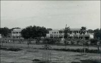Ouagadougou, le collège Saint Jean Baptiste de la Salle (fin des années 1950). – Cet établissement est le fruit de la nouvelle communauté des Frères des Ecoles Chrétiennes de Ouagadougou, fondée en 1953 par deux frères issus de la communauté de Tousiana dans l’ouest du pays. Les frères Yves Paul et Emile, bientôt rejoints par le frère Louis Kremer, assurent la relève des sœurs blanches dans le fonctionnement de l’école primaire de la Salle, laquelle sera cédée à l’enseignement public en 1969. Parallèlement ils organisent l’enseignement au collège, dont la classe de sixième ouvre dès 1953, suivie entre 1954 et 1956 par les classes de cinquième, quatrième et troisième. Initialement installé dans de simples locaux en banco, le collège va progressivement intégrer les actuels bâtiments, à partir de 1957 et au gré de l’achèvement des travaux.