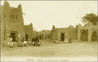 Zinder, maisons de commerçants tripolitains. – Description de Zinder en avril 1902, quand y entre le commandant Gouraud : « Zinder est le grand centre de transit de cette partie de l’Afrique centrale. […] Au Nord, à 1500 mètres [de Zinder], se trouve la ville Targuie de Zengou. […] On y rencontre des Tripolitains, quelques Touareg. Elle compte 4 à 5000 habitants. […] Le marché de Zengou est animé. On y trouve en particulier de beaux cuirs,  les bottes en filali de toute l’Afrique centrale et que nous portons nous-mêmes, des brides brodées ; les bijoux ne valent pas les délicats filigranes des bijoux soudanais et sénégalais ; il y a de jolies calebasses ouvragées de toutes dimensions, la calebasse pouvant servir d’écuelle aussi bien que de malle aux femmes du pays, qui y empilent leurs étoffes et leurs ustensiles et la portent sur la tête. On y voit des musiciens, des danseuses, aux cadences lentes et balancées, un homme-orchestre. Il y a encore sur le marché de Zengou du sel de Bilma, comme à Tombouctou du sel de Taodénit ». Source : Gouraud, Général, Zinder, Tchad - Souvenirs d'un Africain, Paris, Plon, 1944.