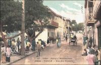 Dakar, rue des Essarts. – Cette artère, qui conserve de nos jours son tracé initial, est l’une des plus anciennes de la capitale sénégalaise. Son nom, qui n’a jamais changé,  fait vraisemblablement référence au défrichage nécessaire à son édification. Elle fut dessinée ex nihilo en 1862 - cinq ans seulement après l’installation française sur la presqu’île du Cap Vert - par le capitaine du génie Pinet-Laprade. Celui-ci organisa le premier plan d’urbanisme de la ville, en s’inspirant du modèle d’une petite bourgade de province : il jette ainsi un boulevard portant son nom, quelques rues perpendiculaires et parallèles, dont la rue des Essarts, et une place centrale accueillant les activités de commerce, la place Kermel et le marché du même nom. Haut-lieu du quartier historique, la rue des Essarts accueillera, au fil du temps, le siège, la succursale locale ou la représentation pour l’AOF – dont Dakar était la capitale depuis 1902 -  de nombreux opérateurs économiques et commerciaux, comme le Crédit Lyonnais, les magasins de confection « Ghislaine » et « Jaoudi », la CITEC – fournisseur officiel de « La toile d’avion » -, la Société anonyme de ravitaillement maritime… - Cette carte postale fait partie de l’importante collection due au photographe et éditeur dakarois Edmond Fortier (1862-1928), qui tenait d’ailleurs boutique rue Dagorne, une des voies transversales coupant la rue des Essarts au niveau du marché Kermel.
