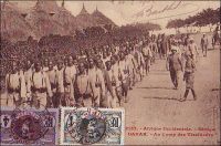 Dakar, au camp des tirailleurs. - 212 000 Africains, de toute l’AOF, prirent part en tant que tirailleurs sénégalais aux hostilités de la Grande guerre, dont 165 000 sur le sol métropolitain. 30 000 furent tués. Le corps des tirailleurs sénégalais avait été créé en 1857 par Louis Faidherbe, alors gouverneur général de l’AOF, pour palier, en cette époque de conquête coloniale, le déficit de troupes venant de Métropole. Initialement composée d’esclaves rachetés à leurs maîtres africains et affranchis, et de volontaires issus des élites locales, les régiments de tirailleurs sénégalais s’apparentent à des troupes mercenaires. Mais la mobilisation de tous les Africains de plus de 18 ans décidée en 1915, et l’engagement pour défendre la Nation vont en faire un corps d’engagés et de conscrits des plus légitimes. 17 régiments de tirailleurs sénégalais participent à la bataille de la Somme, subissant d’importantes pertes qui vaudront au Général Mangin, par ailleurs promoteur des troupes africaines, le surnom de « boucher des noirs ». - Cette carte postale fait partie du travail du célèbre photographe et éditeur dakarois Edmond Fortier (1862-1928) à qui l’on doit une somme importante de clichés sur l’Afrique de l’Ouest en général et sur le Sénégal en particulier ; il a publié en tout 3300 clichés originaux. M. Fortier tenait boutique et vivait avec ses deux filles blondes et son boy Seydou Traoré, à l’angle de la rue Dagorne et du boulevard Pinet-Laprade.