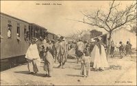 Dakar, en gare. – « Le train du Soudan part tous les mardis. Alors les bateaux s’arrangent pour arriver le mercredi ! [...] Les voyageurs arrivaient avec tant de colis que tous avaient l’air d’épiciers en gros qui déménageaient ! [...] Un beau noir me précédait au guichet. Un électeur de Blaise. Ainsi ses frères appellent-ils M. Diagne. L’électeur était coiffé d’un chapeau dit melon et qui avait du servir une quinzaine d’années, comme objet d’expérience, à ces camelots de rues barrées, vendeurs de savons qui détachent ! « Tiens, donne m’en pour cinquante francs. » La traite des arachides terminée, les Sénégalais ont un peu d’argent ; alors ils vont se promener. Ils ne vont ni à Thiès, ni à Saint-Louis, ni à Kayes. Ils vont jusqu’à cinquante, quatre-vingts, cent francs, suivant leur fortune. Aux arrêts ont les voient à la portière criant : « Bonjour, Mamadou ! Bonjour, Galandou ! Bonjour, Bakari ! Bonjour, Gamba ! » Ils se montrent à leurs connaissances dans la noble situation de voyageur. Ils sont fiers. Après, ils reviennent - à pied ! Le train démarra, il allait courir sur douze cents kilomètres de voie ». Source : Londres, Albert, Terre d’ébène, Paris, Albin Michel, 1929.