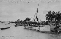 Saint-Louis, les bords du petit bras du fleuve à Guet-N’Dar. - « La ville de Saint-Louis est bâtie sur une langue de sable, qu’on peut à la rigueur appeler une île, située presque au point de départ de deux bras du fleuve Sénégal, à environ douze mille de son embouchure. Cet îlot atteint à peine trois kilomètres de long, sur une largeur qui n’excède pas deux cents mètres ; sur toute l’étendue de la ville règnent des quais ou maçonneries bâtis sur pilotis. […] Saint-Louis communique par deux magnifiques ponts à la terre ferme, le pont fixe de Guet N’Dar sur le petit bras, et le pont de bateau mobile sur le grand bras, appelé pont de Sor. » (1) - Le quartier de Guet N’Dar, où vivaient et travaillaient dès la moitié du XIXème siècle les grandes familles de commerçants métis comme les Devès, les Carpot ou les Guillabert, abrite de nos jours essentiellement des pêcheurs. Source (1) : Jacolliot, Louis, Voyage aux rives du Niger, Paris, C. Marpon et E. Flammarion, 1879.