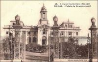 Dakar, Palais du Gouvernement. -  En 1902, tandis que Dakar devient la capitale de l’AOF, la construction du palais est décidée, puis entamée, sur ordre de  Gaston Doumergue, alors ministre des colonies. A l’issue de cinq ans de travaux, le bâtiment est inauguré le 28 juin 1907, et son premier occupant est le gouverneur Ernest Roume, qui a depuis donné son nom à la rue qui passe devant le palais. Tous les gouverneur coloniaux s’y sont succédés, jusqu’au dernier d’entre eux, Pierre Mesmer (1958-1959), avant que l’indépendance n’en fasse le Palais de la République et que ce soient les chefs de l’Etat sénégalais qui y résident. Différentes réfections, menées au fil du temps, ont abouti au style architectural actuel, fait de lignes sobres et monumentales. A l’origine, comme le montre le cliché de Fortier, le bâtiment, surmonté d’une tour inspirée du Trocadéro de Paris, avait une facture néo-classique un plus chargée. - Cette carte postale fait partie du travail du célèbre photographe et éditeur dakarois Edmond Fortier (1862-1928), à qui l’on doit une somme importante de clichés sur l’Afrique de l’Ouest en général et sur le Sénégal en particulier ; il a publié en tout 3300 clichés originaux. M. Fortier tenait boutique et vivait avec ses deux filles blondes et son boy Seydou Traoré, à l’angle de la rue Dagorne et du boulevard Pinet-Laprade.