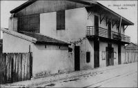 Rufisque, la maire, avant 1904. – La ville de Rufisque s’est développée progressivement à partir du XIVème  siècle sur un site initialement occupé par des villages de pécheurs. Elle va s’imposer au cours du XIXème siècle comme principal centre de traitement et d’exportation de l’arachide, grâce à sa situation géographique, à la porte du Cayor, et à son port. En 1880, 23 000 tonnes d’arachides sont exportées depuis Rufisque, soit plus de la moitié des exportations de la colonie. Centre commercial et administratif important, Rufisque devient une commune avant même Dakar, le 12 juin 1880. L’avènement du chemin de fer, dont la construction commence à la fois à Saint-Louis et à Rufisque en 1883, va renforcer encore la position de la ville. Avec l’ouverture de la ligne vers Djourbel, au début du XXème siècle, l’activité de Rufisque connaît un essor. Cet embryon de la ligne Thiès-Kayes renforce encore le trafic lié à l’arachide. Ainsi, en 1909, 45 000 t. d’arachide sont débarquées à la gare de Rufisque. Mais, dès la fin des années 1920, Rufisque connaît un déclin inexorable. Ses activités portuaires sont concurrencées par celles d’autres villes, Dakar et Kaolack notamment. De plus, son rayonnement a pali depuis que Dakar est devenue en 1902 la capitale de l’AOF, et reçoit la majeure partie des investissements publics. L’âge d’or de Rufisque s’achève définitivement avec la crise économique des années 1930. A visiter : http://www.rufisquenews.com/rufisque_une_ville_une_histoire.html