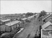 Kayes, la grande rue, vers 1910. Cliché Dr Collomb (coll. Muséum). – « Fondée en 1881 par Borgnis-Desbordes, Kayes, ville créée de toutes pièces, possède actuellement 6000 habitants environ. De nombreuses maisons de commerce y font des affaires qui semblent prospères, à en juger par l’animation qui y règne. Toutefois, m’a fait remarquer l’oncle Guy tandis que nous parcourions la ville, Kayes a beau être la capitale administrative et avoir été munie de tout un outillage économique, c’est toujours Médine qui est restée le grand centre politique et commercial. Au font, Kayes et Médine forment un seul bloc… ». Source : Decourt, Dr Ferdinand, La famille Kerdalec au Soudan, Paris, Ed. Librairie Vuibert, 1910.