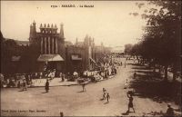 Bamako, le marché. – « Malinkés, Peulhs, Maures au marché. Ce marché n’est pas l’horrible halle en fonte, commandée en France, mais un beau bâtiment à pylônes ; le ciment armé, frère du torchis, se prête parfaitement à l’architecture soudanaise. Tout est d’un rose relevé de la tache noire des corps et des têtes et de la violence bleue des cotonnades, appelées « guinées ». Voici des barres de sel de Mauritanie que compissent des chiens errants non moins ignoble que les chiens chinois ; voici des anneaux de cheville en argent, en aluminium, des bagues d’or, convoités par les moussous (Noires, concubines des Blancs), du gingembre, des coquillages, des cosmétiques, des boules de beurre végétal, à l’odeur infecte, des colliers d’exportation, des fichus de tête » (1). Le marché central de Bamako, aussi appelé marché rose, a été partiellement détruit par un incendie en 1993. Il a depuis été reconstruit. Source : (1) Morand, Paul, A.O.F. de Paris à Tombouctou, Paris, Flammarion, 1928.