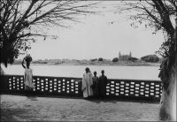 Mopti, vue sur la mosquée. – La grande mosquée de Mopti, appelée mosquée de Komoguel, fut érigée entre 1936 et 1943 sur le site d'une mosquée antérieure, elle-même bâtie en 1908. L’édifice réalisé sous la direction des maçons de Djenné présente de nombreuses similitudes avec la mosquée de cette ville. Construite en briques de terre et recouverte de banco, elle devait partiellement changer d’aspect quand ce revêtement fut remplacé par du ciment, lequel permettait de s’affranchir des opérations annuelles de réfection nécessitées par le banco, à l’occasion d’une restauration datant de 1978. Mais cette opération, employant des matériaux et des techniques inadaptés, avait fragilisé l’édifice. Une récente réhabilitation, empruntant des savoir-faire traditionnels, et notamment l’emploi d’un enduit réalisé à base de terre et de balle riz appelé « banco pourri »,  lui a rendu son aspect originel. - En 1947, époque à laquelle fut prise cette photo, la ville de Mopti est le chef-lieu d’un vaste cercle de 67 300 km2, qui compte une population de « 71 Européens, 16 Américains, 97 Libanais et 450 000 Africains » (1). Source : (1) Guid’AOF, Dakar, 1948.