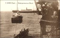Lomé, embarquement au wharf. – L’épreuve du « panier », suspendu à une grue du wharf, est l’étape obligée à Lomé, pour monter à bord des navires ou descendre à terre. Le journaliste Jean Martet, qui fit un voyage au Togo et au Cameroun au début des années 1930, décrit ainsi l’aventure : « Le supplice du panier commence. […] J’ai pris place dans le panier. Le panier n’est naturellement pas un panier. Le panier est une espèce de caisse en bois, sans couvercle ; on dirait un peu une de ces balancelles comme il y en a dans les manèges de chevaux de bois. Seulement dans les manèges de chevaux de bois c’est habituellement peint en rouge, avec des dessins d’or. Ici c’est peint en gris, comme les torpilleurs. De plus, c’est muni par en dessus d’une armature de fer : les anses de ce panier. Je suis donc monté là-dedans […] Je me suis assis sur l’une des deux banquettes dont la balancelle est garni […] J’ai dit à Bernard : On n’aurait donc pas pu trouver quelque chose de plus pratique ? Ça ? m’a-t-il répondu. Qu’est-ce que vous voulez de plus pratique ?   ». Sources :  Martet, Jean, Les bâtisseurs de royaumes, Paris, Albin Michel, 1934.