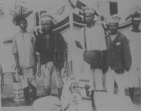 Fonctionnaires indigènes de la poste impériale allemande à Lomé. – Le courrier, avant la mise en service du chemin de fer au Togo en 1905, était acheminé à pieds. Les employés des postes partaient de chaque extrémité de la route – d’Aného vers Lomé et de Lomé vers Aného pour la voie côtière - et se rencontraient à mi-chemin en un point convenu où ils échangeaient leur chargement postal avant de rebrousser chemin en direction de leur bureau de poste d’origine. Entre Lomé et Aného, l’échange avait lieu au niveau du poteau télégraphique n°221, et l’ensemble du trajet prenait la journée, de 7 heures à 16 heures. Entre Kpalimé et Lomé – un service entre les deux villes fut créé en 1902 - il fallait compter trois jours. La mise en service du train permis de raccourcir considérablement les délais, notamment sur les longues distances vers l’intérieur du pays. En 1912, le service postal allemand au Togo était constitué de 16 bureaux de poste disposant d’un télégraphe, de 6 bureaux auxiliaires, et d’un réseau de téléphone urbain. Cette même année, 486 606 lettres furent acheminées dans la colonie, ainsi que 15 116 paquets, 39 695 télégrammes, 113 296 exemplaires de journaux ; 54 285 communications téléphoniques furent passées.