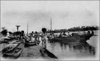 Une vue sur les bords de la lagune de Porto-Novo. – La ville de Porto-Novo est reliée, dès la fin du XIXème siècle, à Cotonou et à Lagos (Nigeria) deux fois par semaine par la voie lagunaire, grâce à des pirogues de 10 à 20 t. Un peu plus tard, la mise en service du chemin de fer, opérationnel en 1929, puis des ponts de Cotonou en 1930 et de Porto Novo en 1938, permet des liaisons ferroviaires quotidiennes avec Cotonou devenue progressivement capitale de fait. La ville de Porto-Novo est le chef-lieu du cercle du même nom et le lieu de résidence, avec Cotonou, du Gouverneur général de la colonie. Le cercle compte en 1947 une population de 500 Européens et 324 817 Africains. Source : Guid’AOF, Dakar, Agence Havas AOF, 1948.