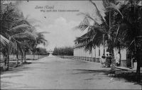Lomé, Krumen halant une chaloupe sur la plage, vers 1900. – Les Krumen, connus comme fameux marins, sont recrutés sur la côte atlantique entre l’Ouest de la Côte d’Ivoire et le Libéria. Leurs compétences sont appréciées, tant sur les bâtiments navigant à la côte africaine, que comme équipages sédentaires chargés de faire franchir la barre aux escales. Avant la construction du wharf par les Allemands, entre mars 1902 et janvier 1904, marchandises et passagers débarquant à Lomé devaient affronter le péril de la barre. Tandis que les premières étaient souvent confiées aux vagues pour gagner la plage, les seconds empruntaient les chaloupes pilotées par les Krumen. La population de Lomé comptait, au dénombrement de 1900, quelques 111 Libériens, qui ne sont autres que ces Krumen formant les équipages des baleinières et autres surfboats qui allaient à la rencontre des navires au mouillage en rade foraine.